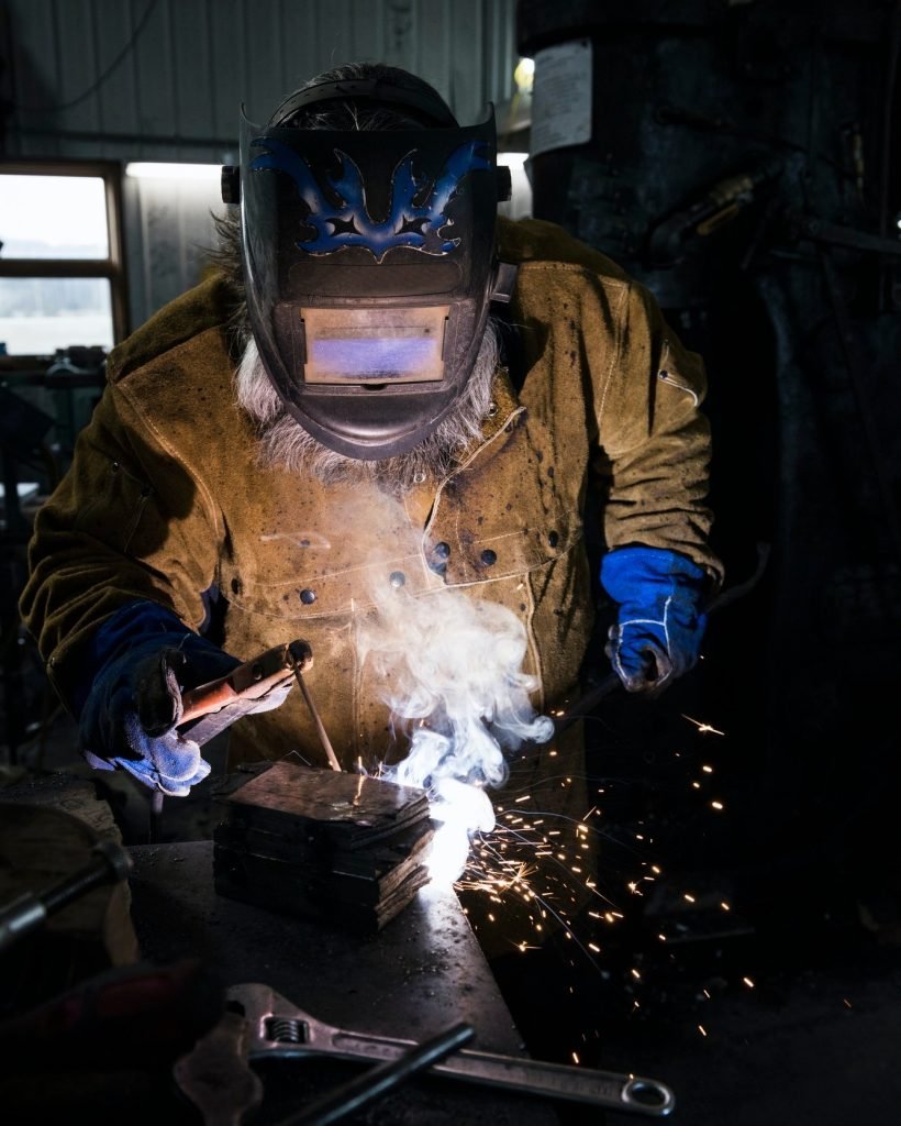 blacksmith-in-welding-mask-welding-metal-in-workshop.jpg